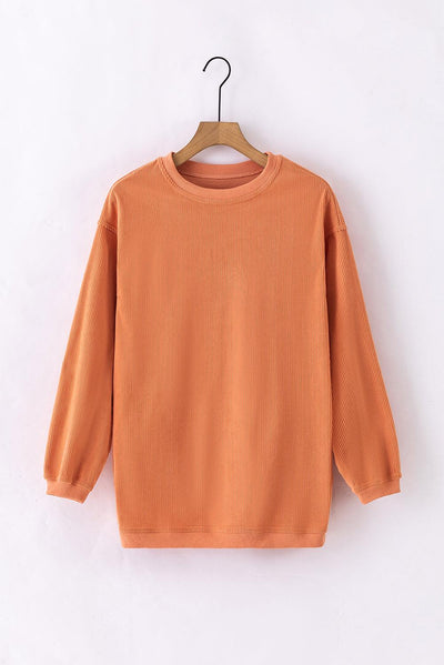 Back of orange ribbed sweatshirt on hanger