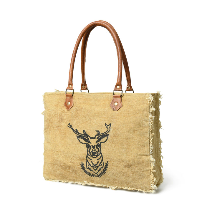 Beige tote bag with brown handles and a deer head design on a white background