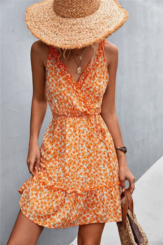 Woman wearing an orange floral dress and straw hat against a gray background