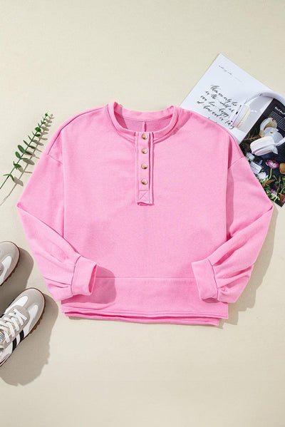 Flat lay of sachet pink buttoned neckline sweatshirt