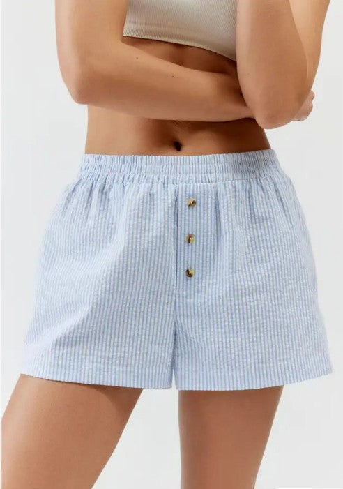 Light blue seersucker shorts worn by a person on a white background