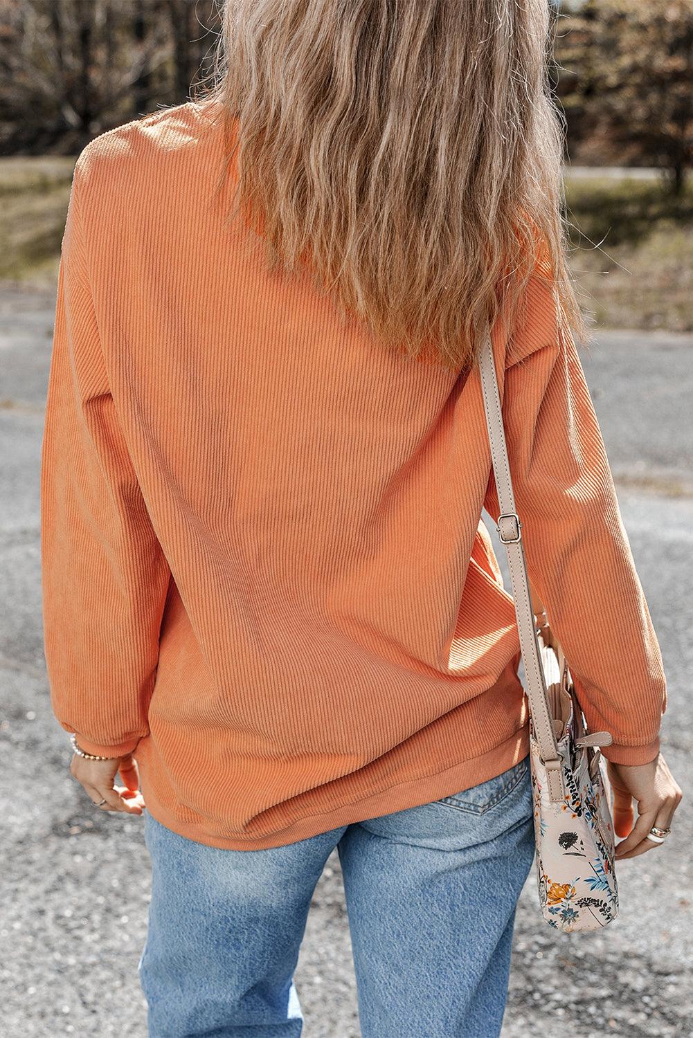 Back view of orange ribbed corduroy oversized sweatshirt