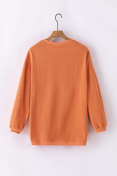 Close-up of ribbed neckline on orange sweatshirt