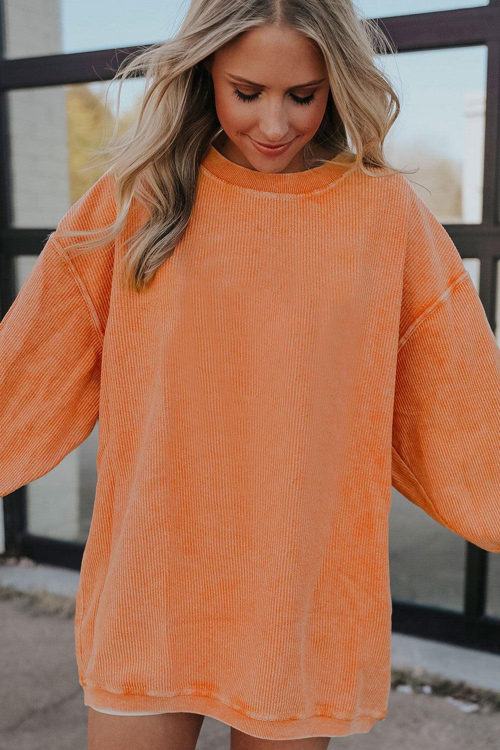 Model wearing orange ribbed oversized sweatshirt