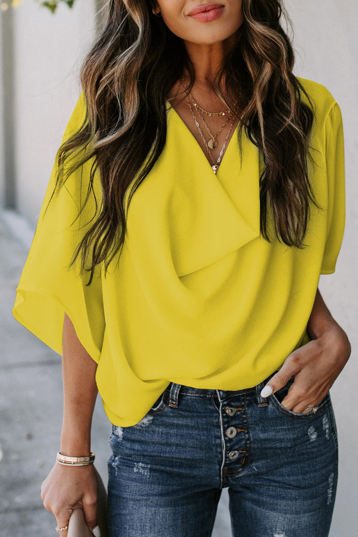 Woman wearing a yellow blouse and blue jeans with a blurred background