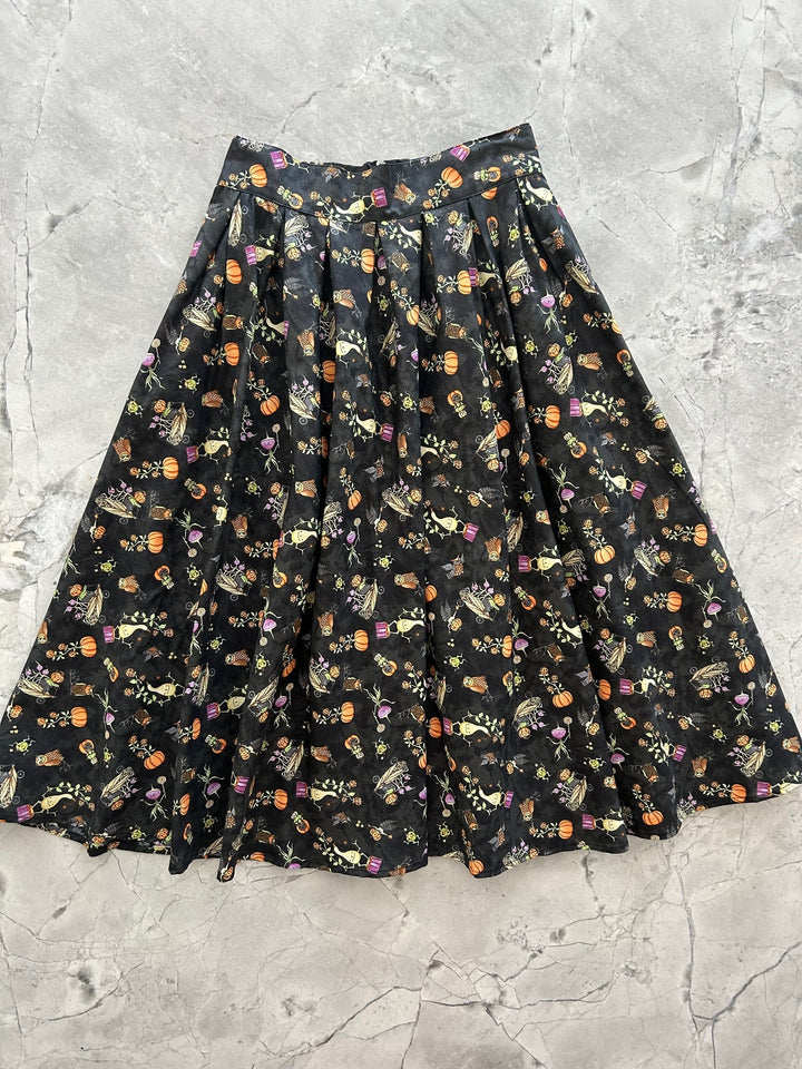 Black skirt with Halloween-themed pattern on a gray surface