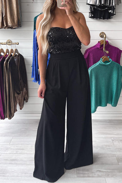 Black sequin tube top jumpsuit in boutique setting