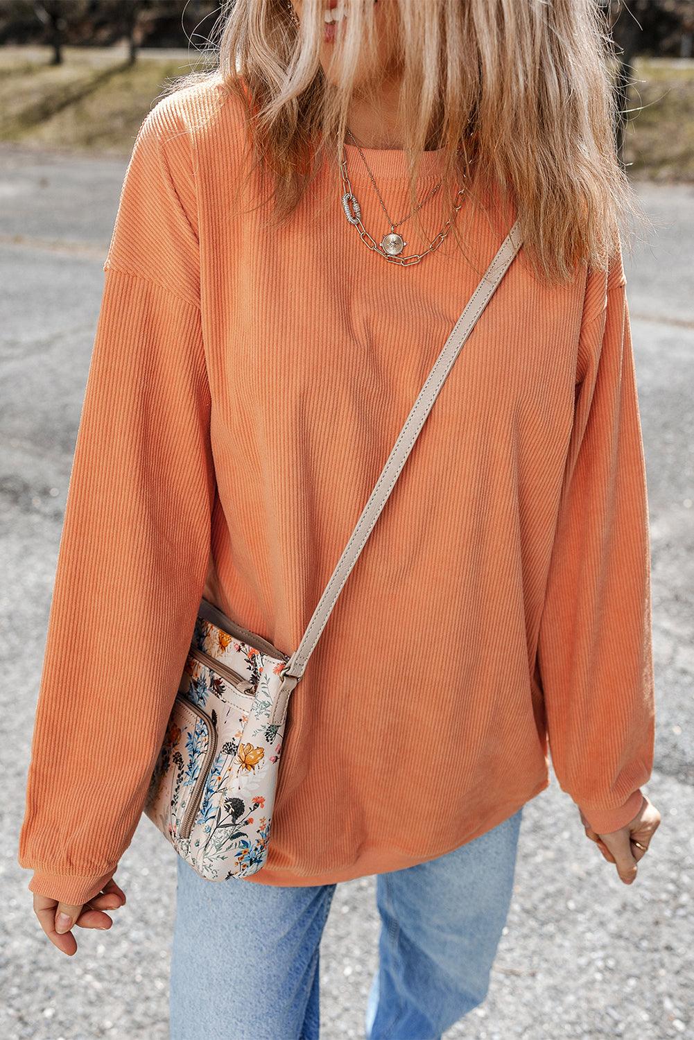 Orange ribbed corduroy sweatshirt with floral bag