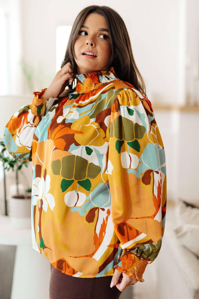 Floral mock neck blouse, styled casually indoors.