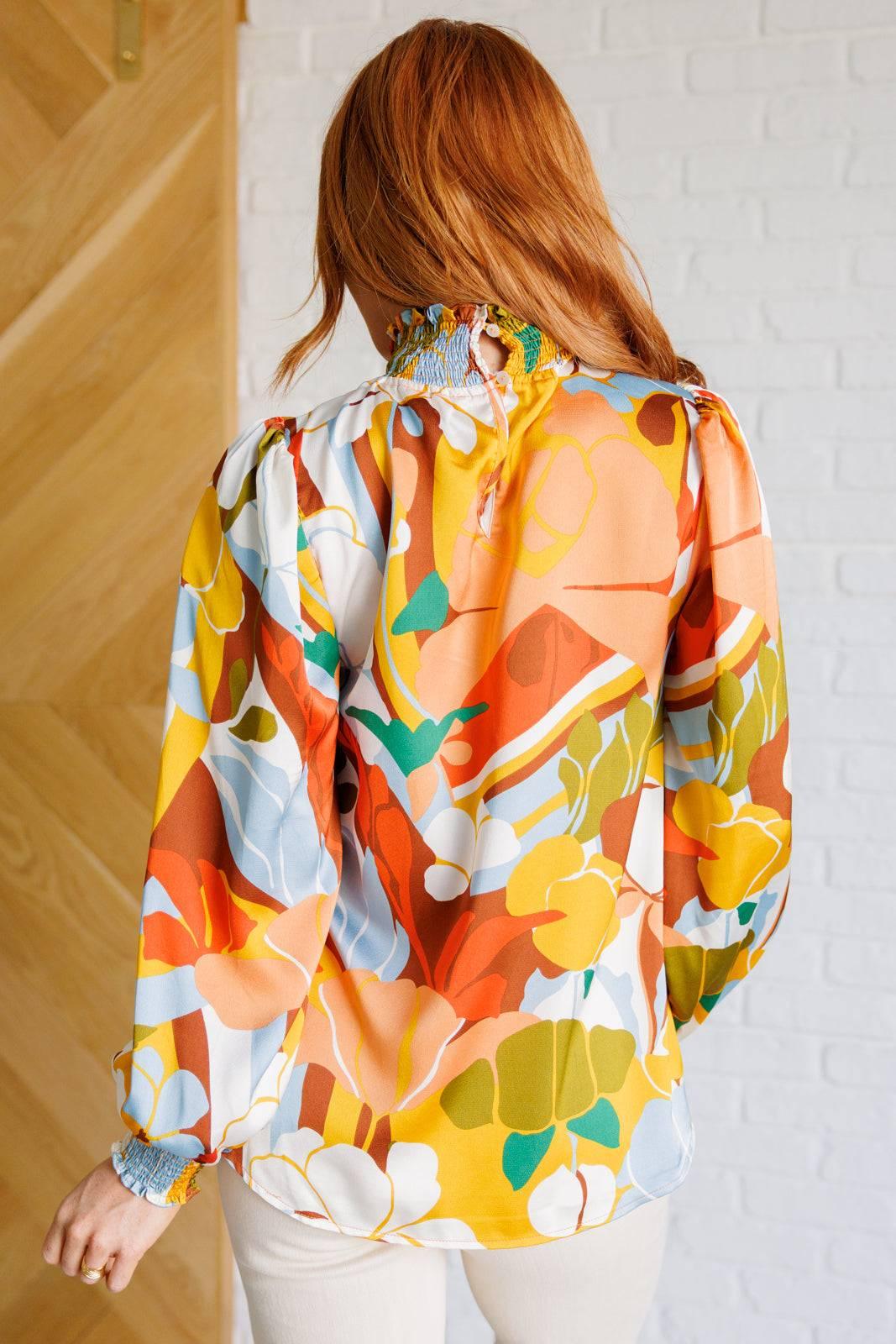 Back view of vibrant floral mock neck blouse.