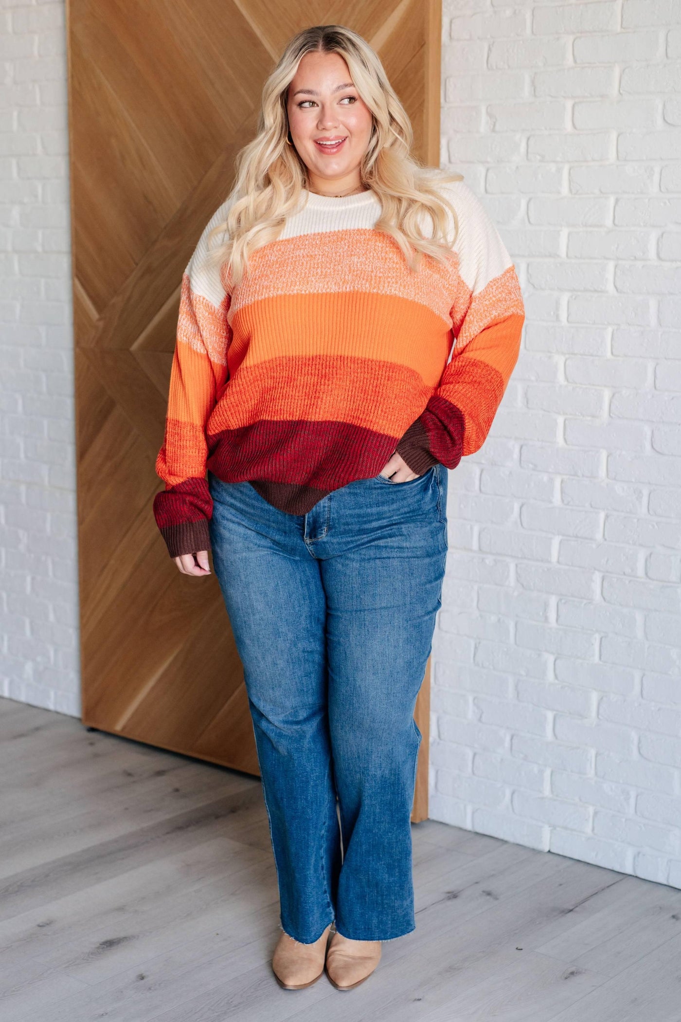 Model wearing All Too Well color block sweater with jeans.