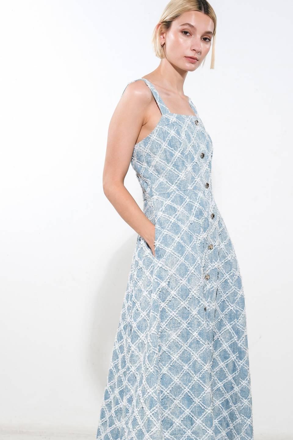 Side view of denim midi dress with button front and pockets.