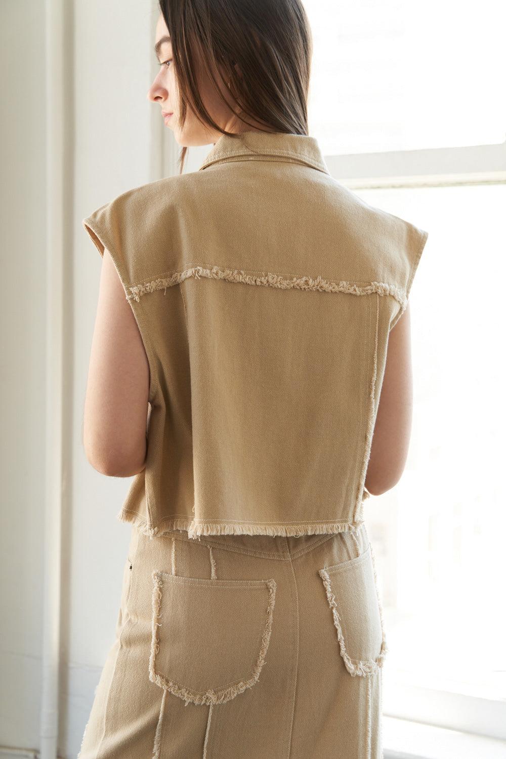 Back view of taupe woven twill vest with frayed details.