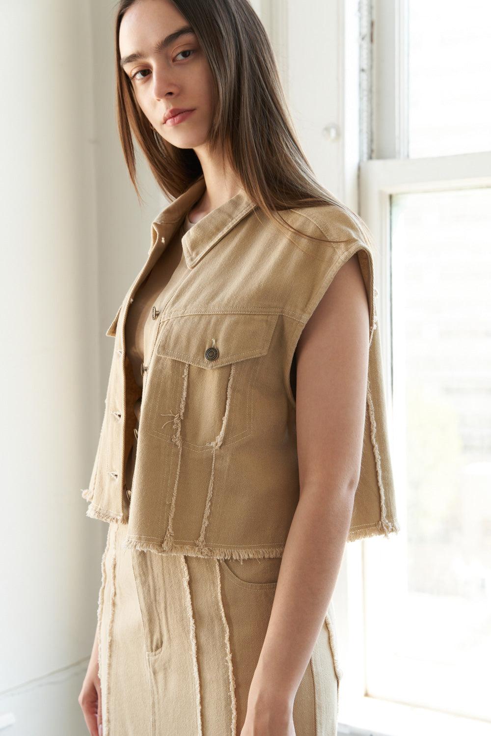 Side view of taupe woven twill vest with frayed edges.