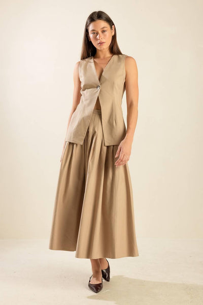 Model in beige vest and skirt ensemble