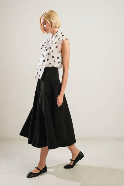 Model wearing black woven skirt with polka dot top