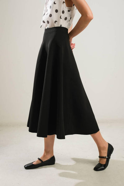 Side view of black woven skirt with flats