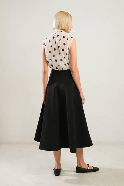 Back view of black woven skirt with polka dot top