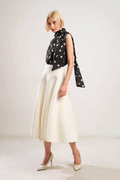 Model in off-white woven skirt with black polka dot top