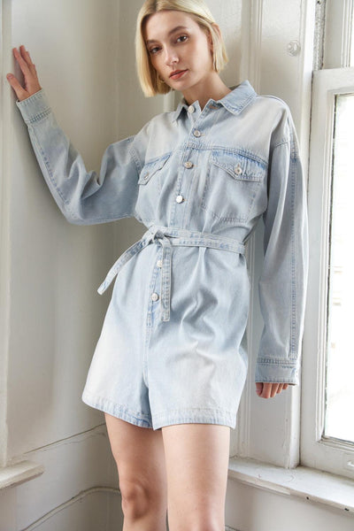 Light indigo denim romper with belt, front view.