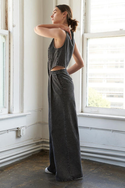 Side view of black denim jumpsuit, wide-leg design.