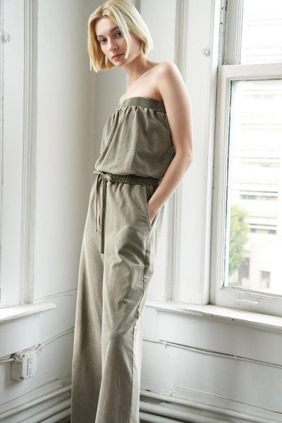 Model wearing olive knit jumpsuit, side view