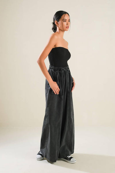 Black strapless jumpsuit with wide-leg pants, side view.