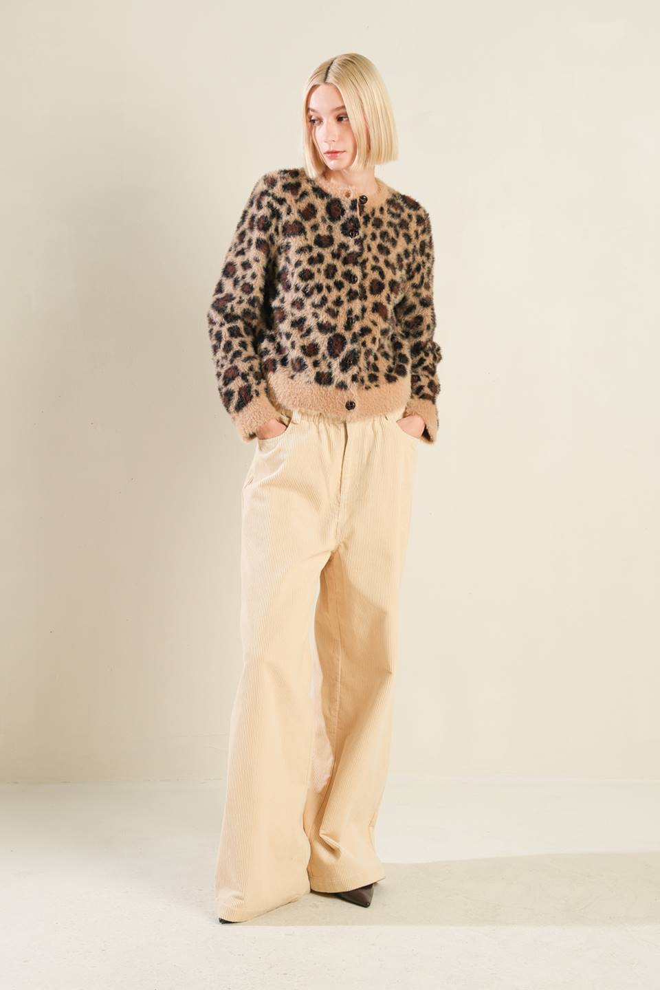 Standing view of taupe/black leopard print sweater cardigan