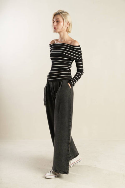 Profile view of black and white striped off-shoulder sweater