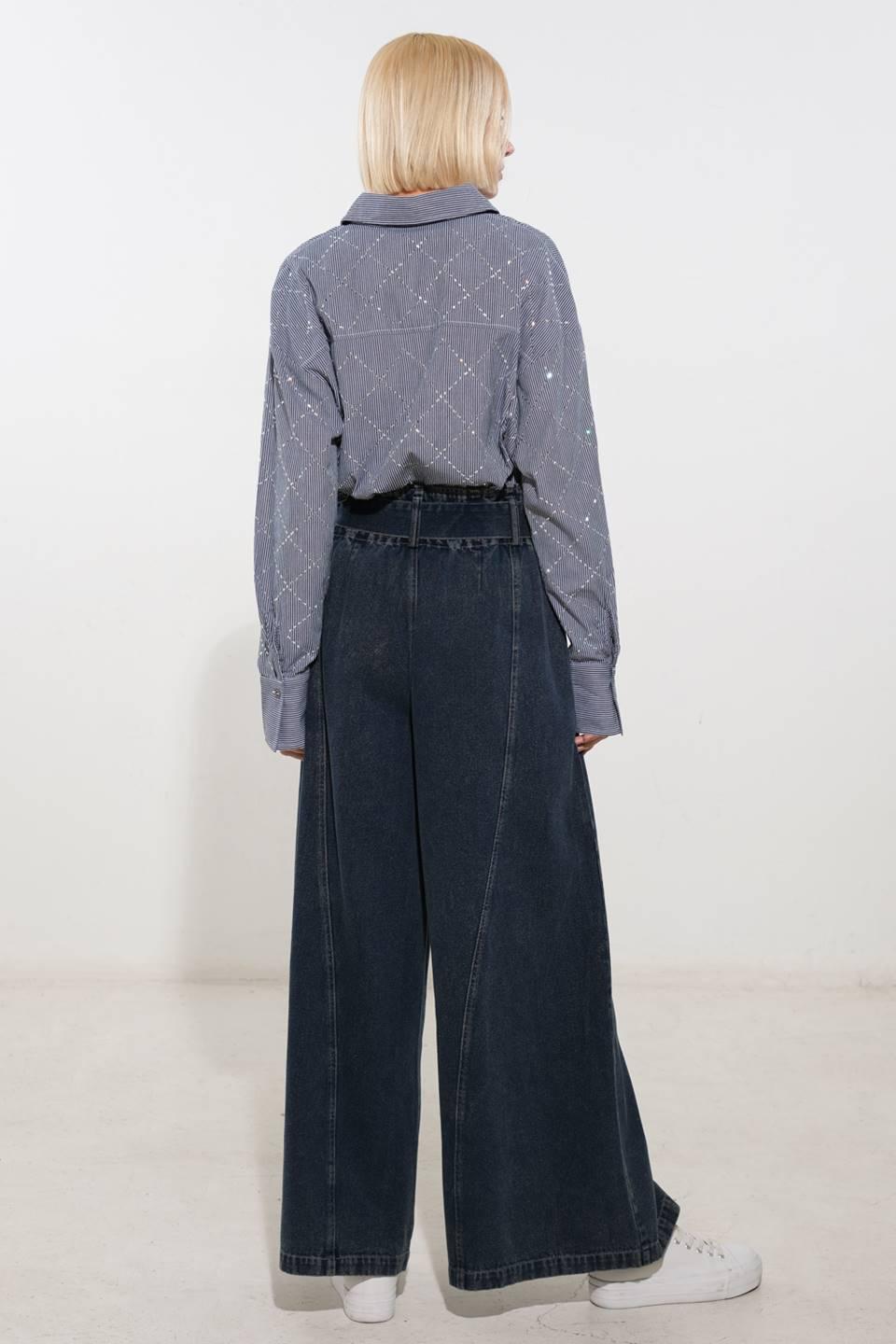 Back view of navy and white woven top with wide-leg jeans.