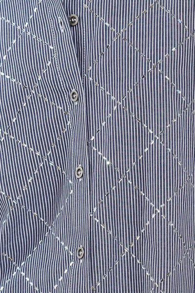 Close-up of navy and white woven top fabric and buttons.