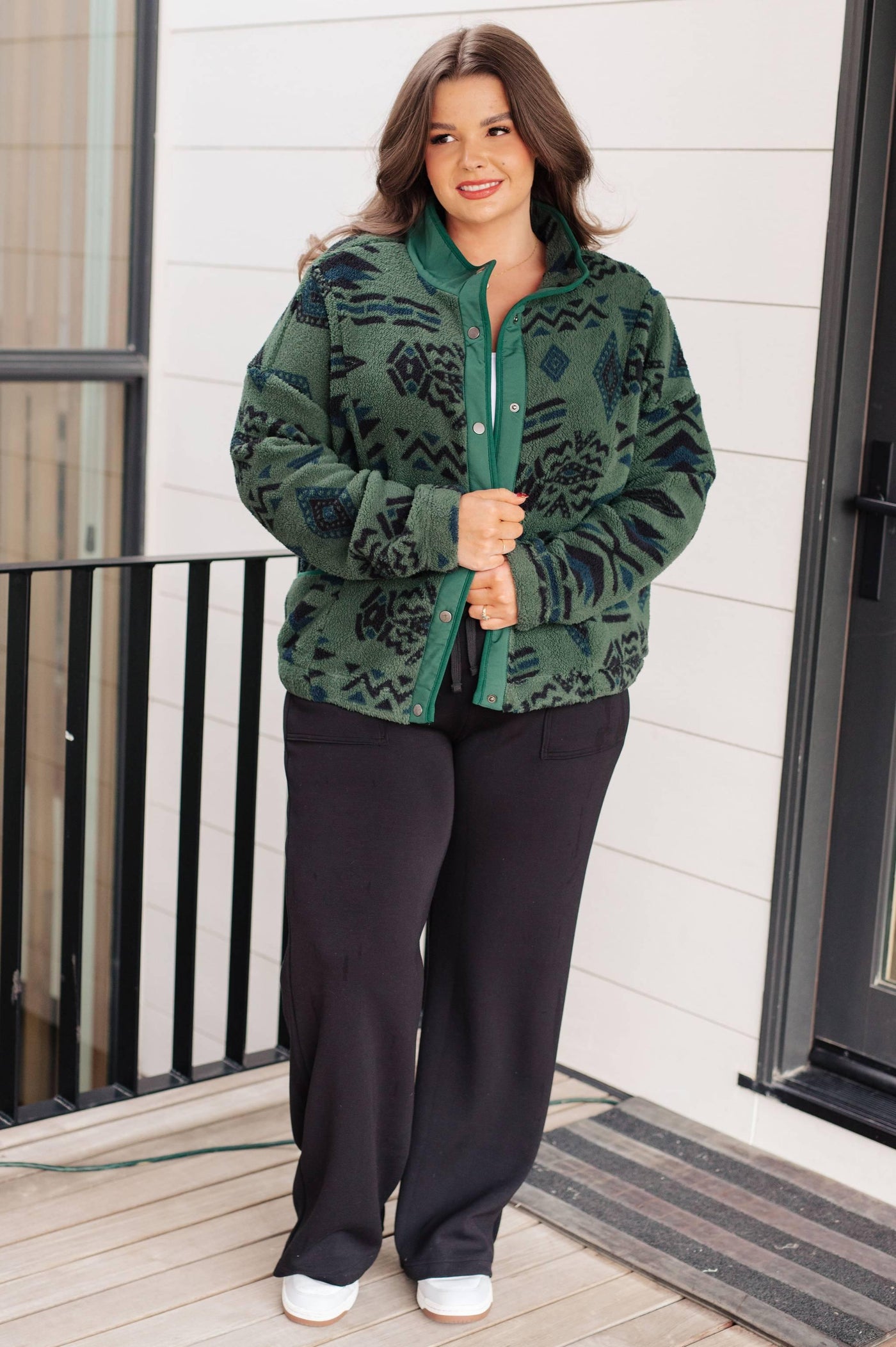 Model in green fleece jacket on balcony