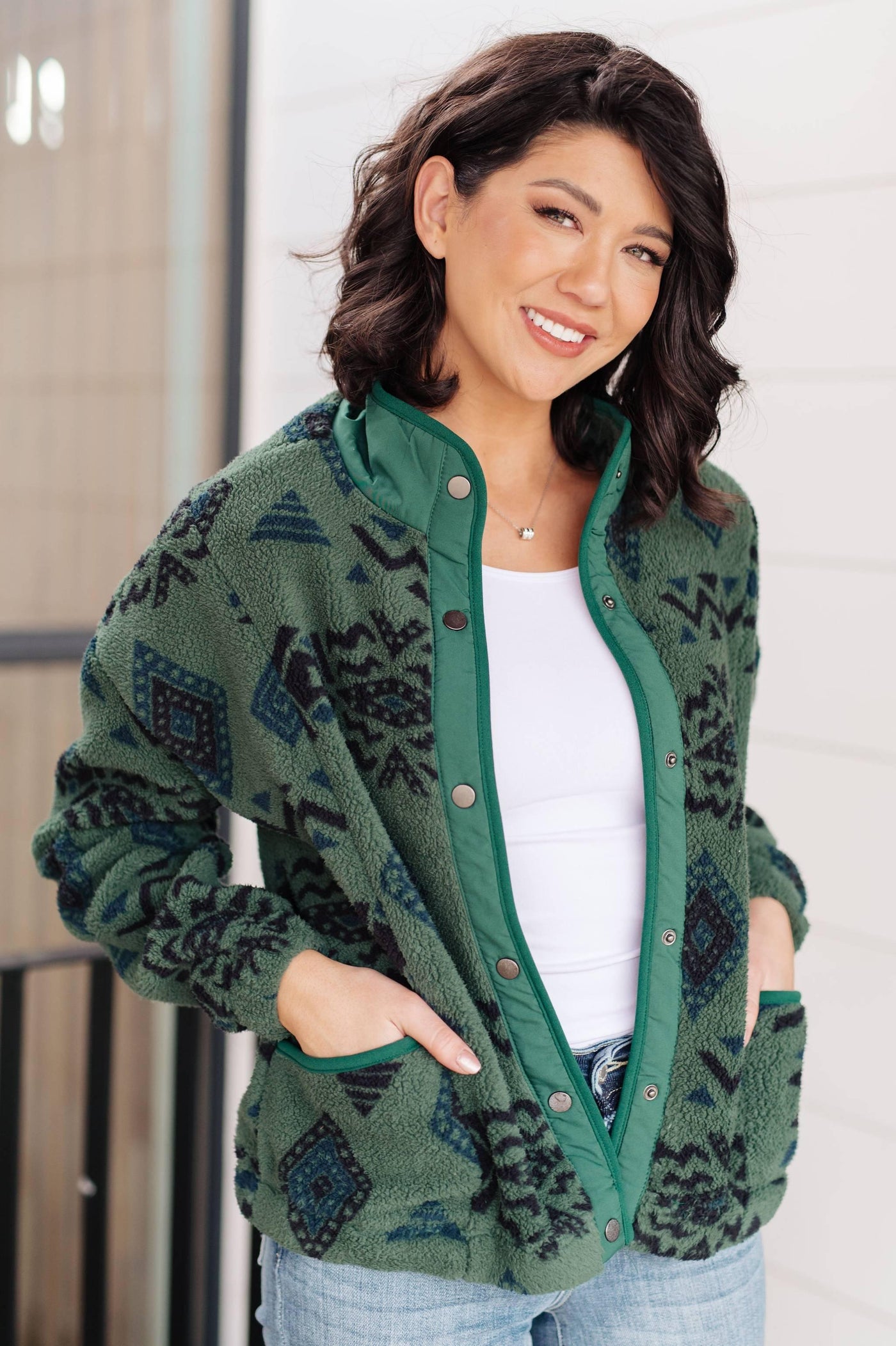 Model in green geometric fleece jacket, smiling