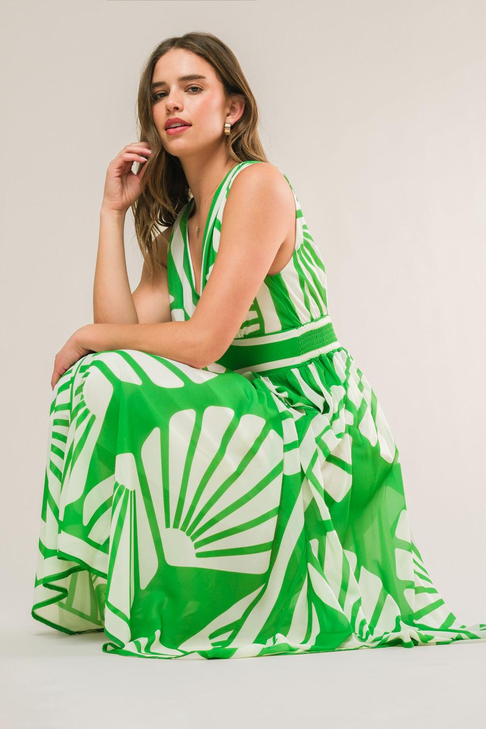 Seated model in green woven midi dress with patterns