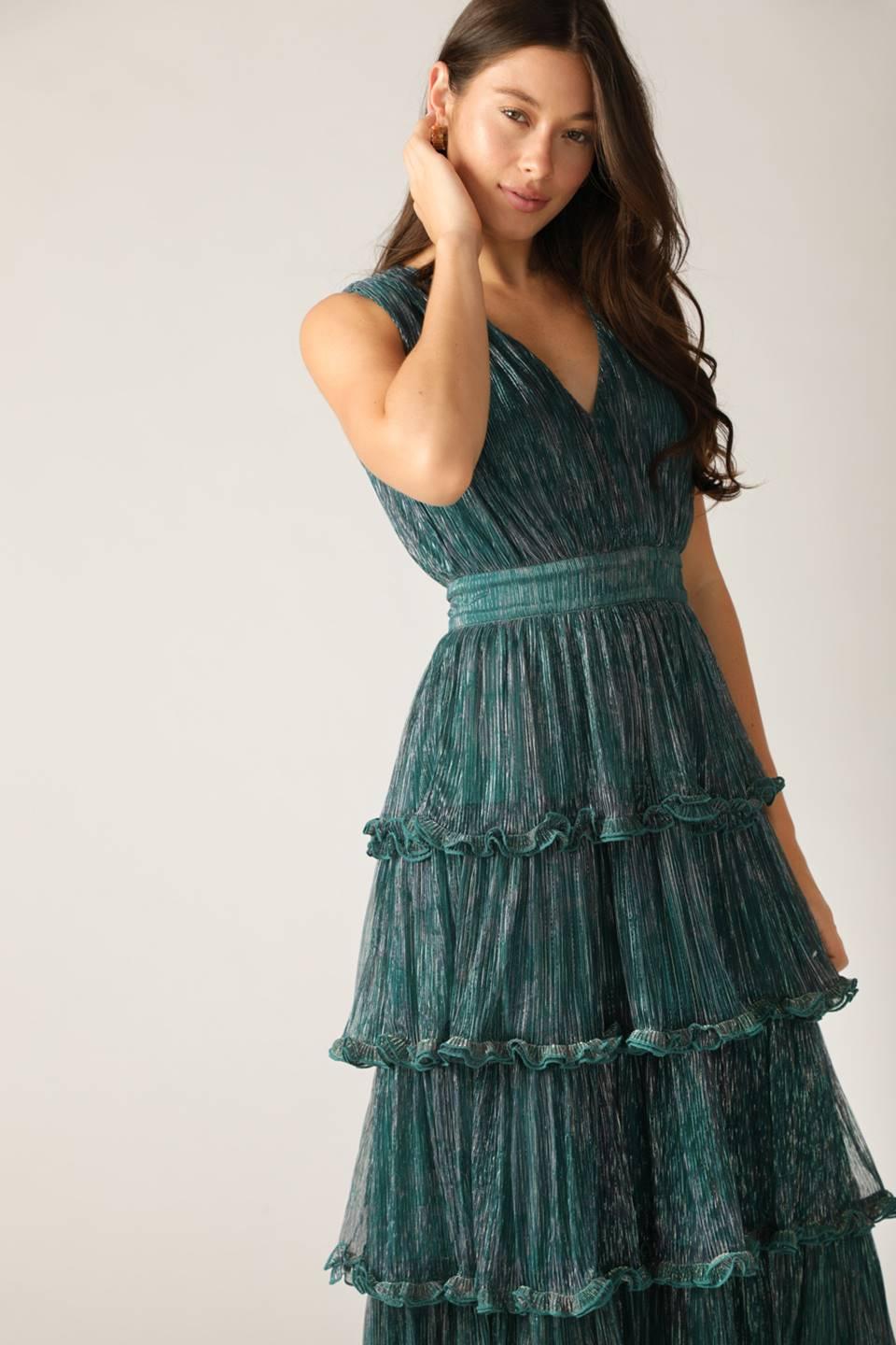 Teal green pleated dress with ruffles, side view.