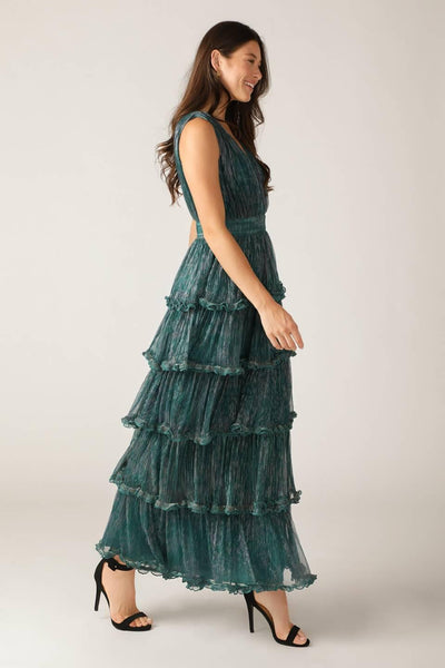 Side profile of teal green pleated maxi dress with ruffles.