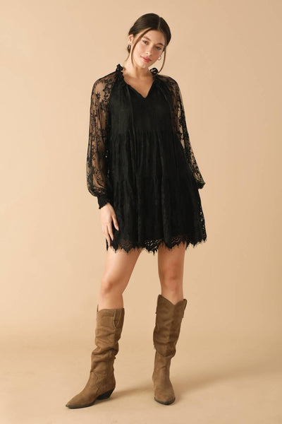 Model wearing black woven lace mini dress with boots