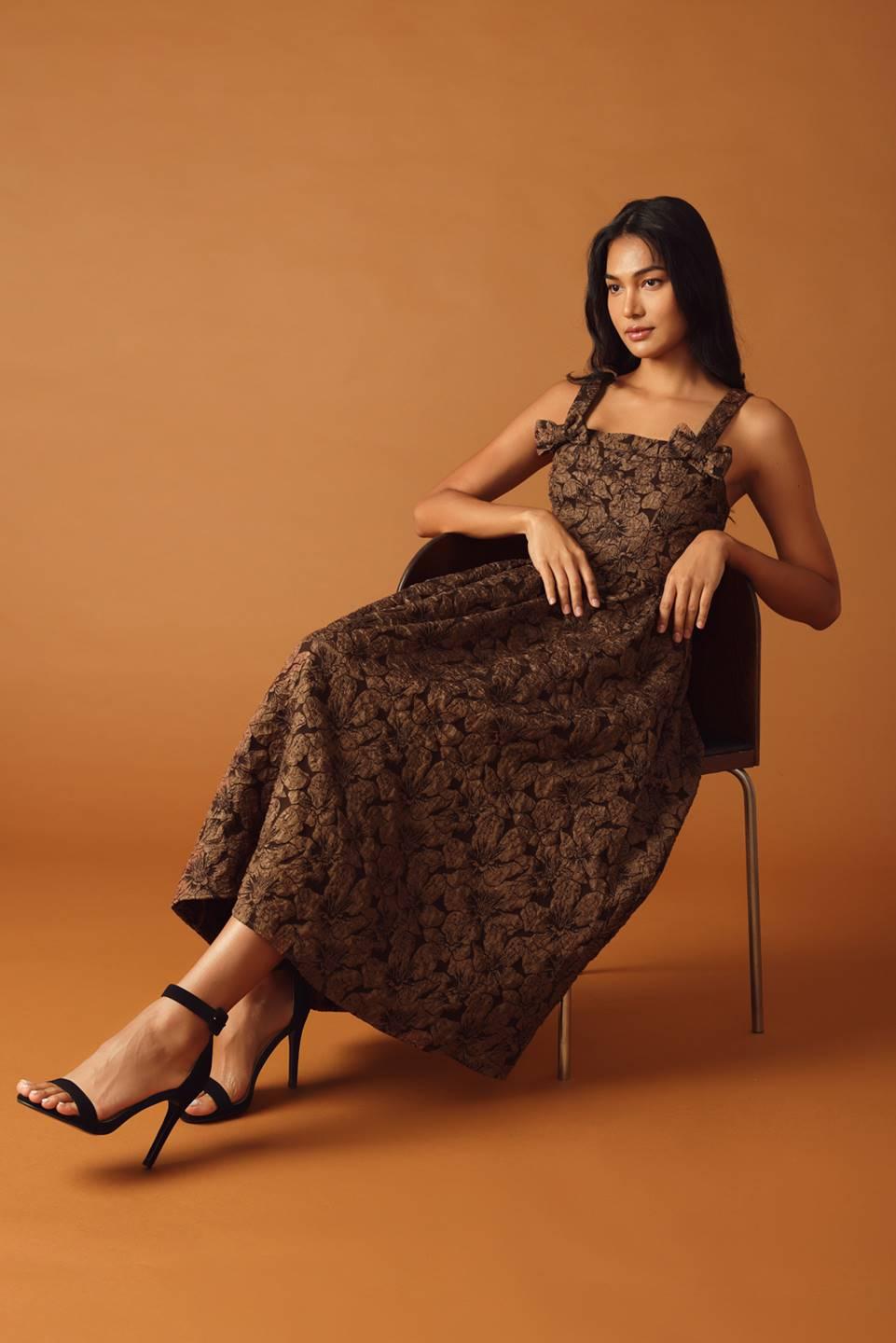 Model seated in brown woven midi dress, floral pattern