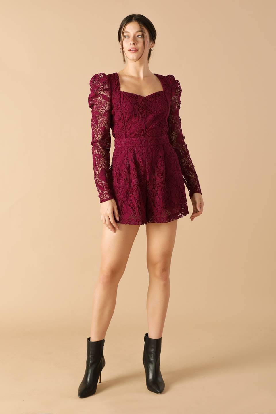 Full view of burgundy lace romper paired with black boots.