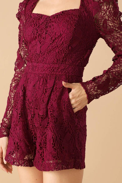 Close-up of burgundy lace romper showing intricate design.