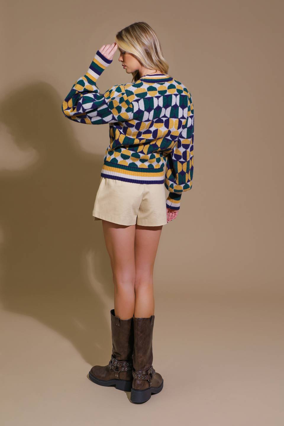 Back view of model in colorful sweater and shorts with boots