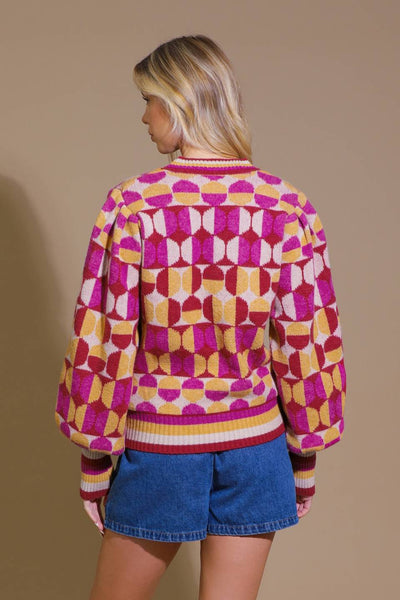 Back view of pink and orange jacquard sweater with denim shorts