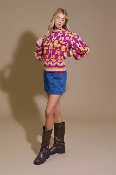 Model in pink and orange jacquard sweater and denim skirt