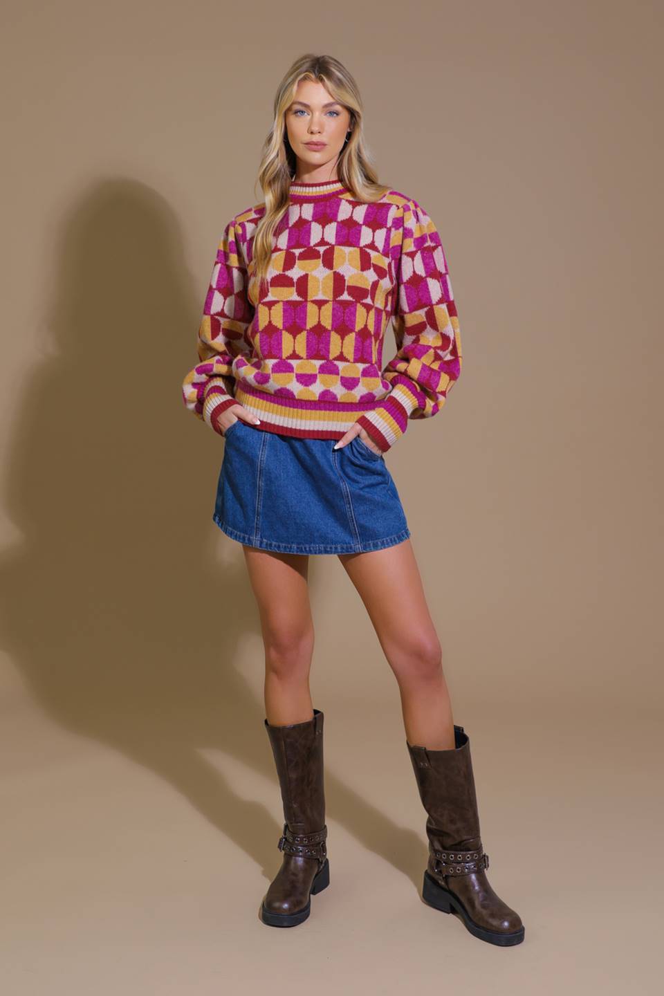 Front view of model in pink and orange sweater with denim skirt