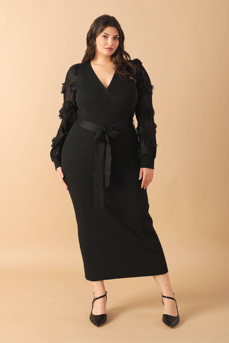 Plus-size model in black sweater midi dress, standing pose