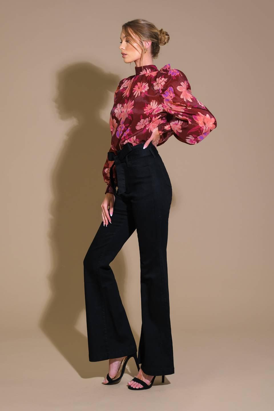 Side view of burgundy floral woven top with black pants