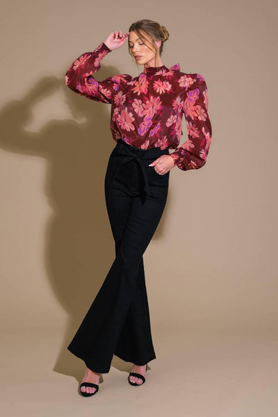 Model wearing burgundy floral top with black flared pants