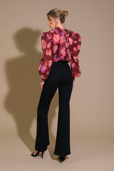 Back view of burgundy floral woven top with black pants