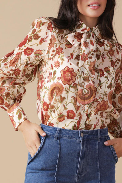 Close-up of ivory floral woven blouse with bow detail