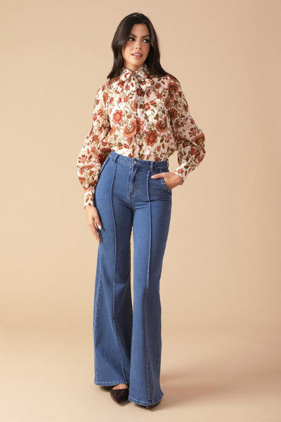 Model in ivory floral blouse and jeans, standing pose